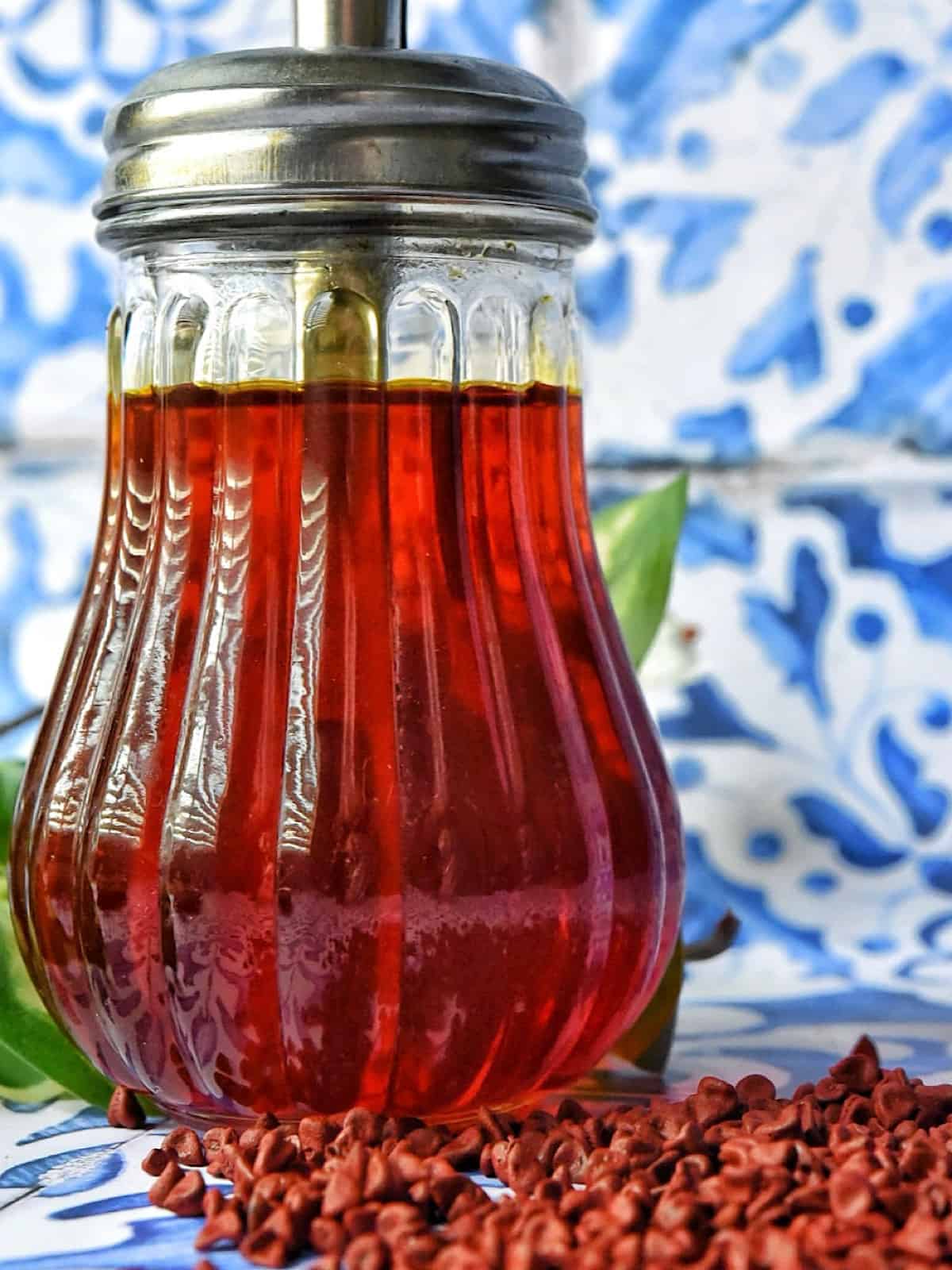 achiote annatto oil in a glass jar with annatto seeds